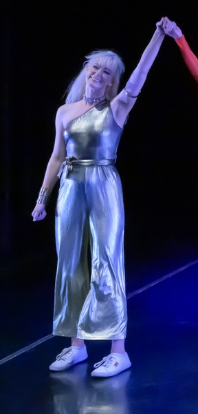 a woman in a silver dress is dancing