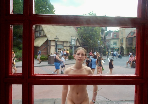 a naked woman standing in front of a window