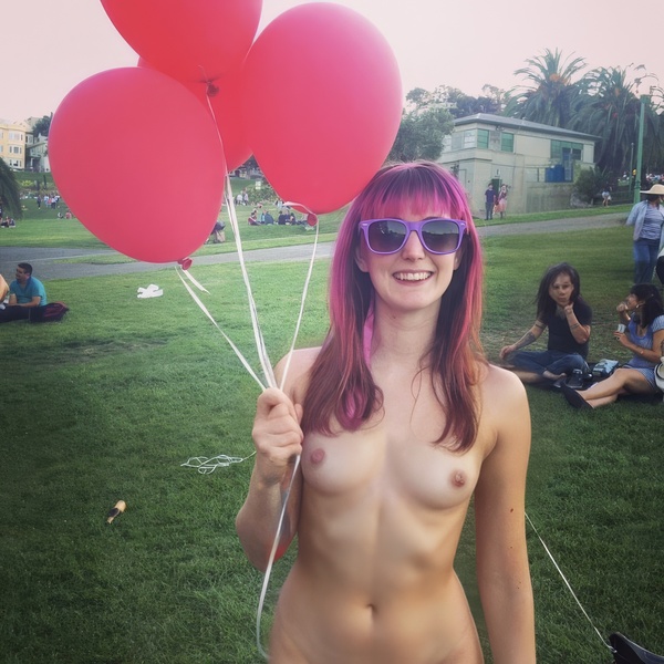 a naked woman holding two red balloons