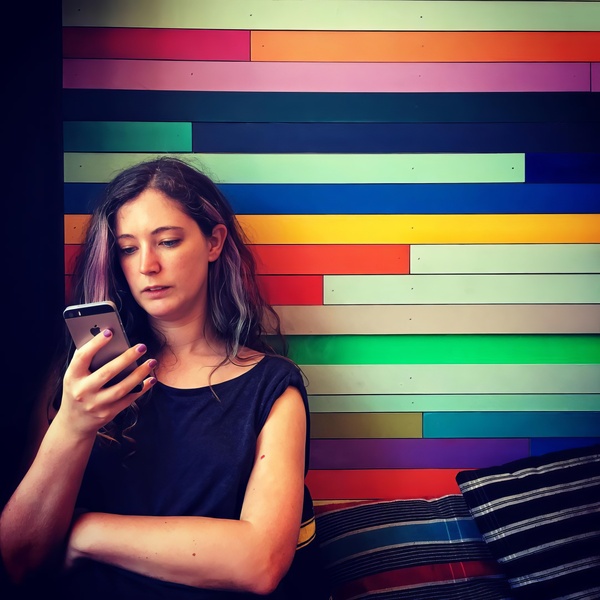 a woman sitting on a couch using her cellphone