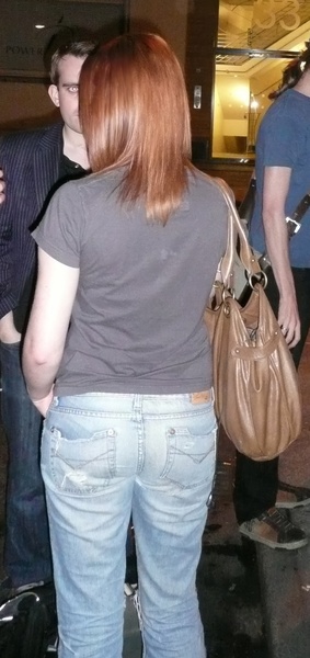 a woman standing in a parking with a purse