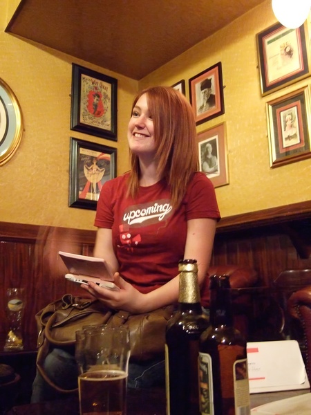 a woman sitting in a bar with a tablet