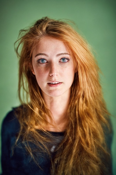 a woman with long red hair and blue eyes