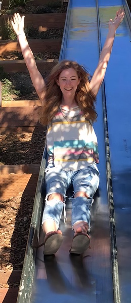 a girl is sitting on a slide