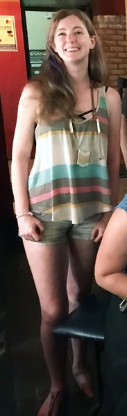 a woman in a striped top and shorts posing for the camera