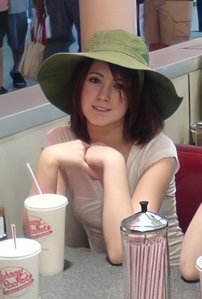 a woman sitting at a table with a drink and a straw