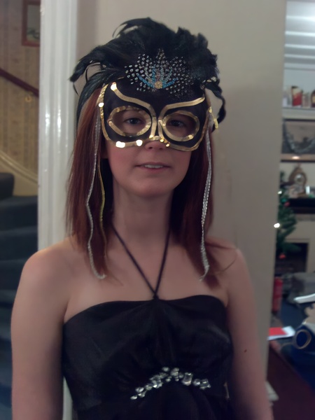 a woman wearing a mask and a black dress