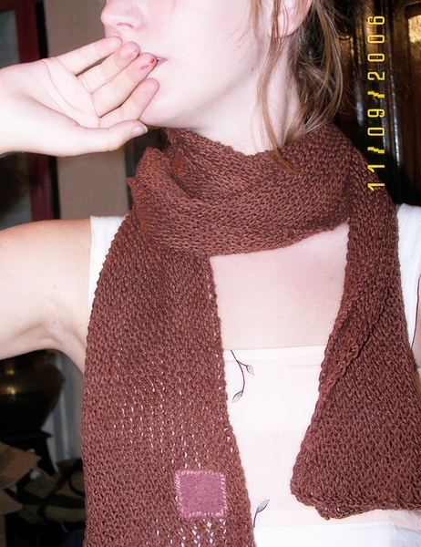 a woman wearing a brown knit scarf oe are

Q002F608LL