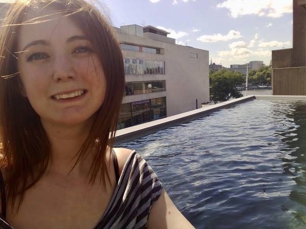 a woman standing in a pool with a building in the background