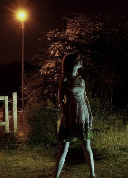 a woman standing in a field at night