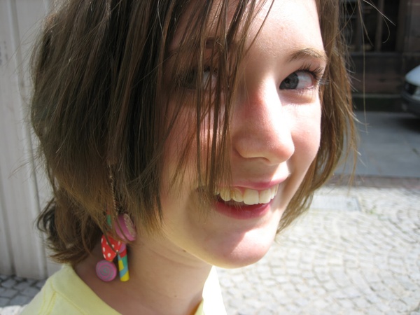 a woman with a yellow shirt and a pair of earrings