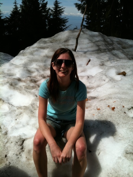 a woman sitting on a rock in the snow