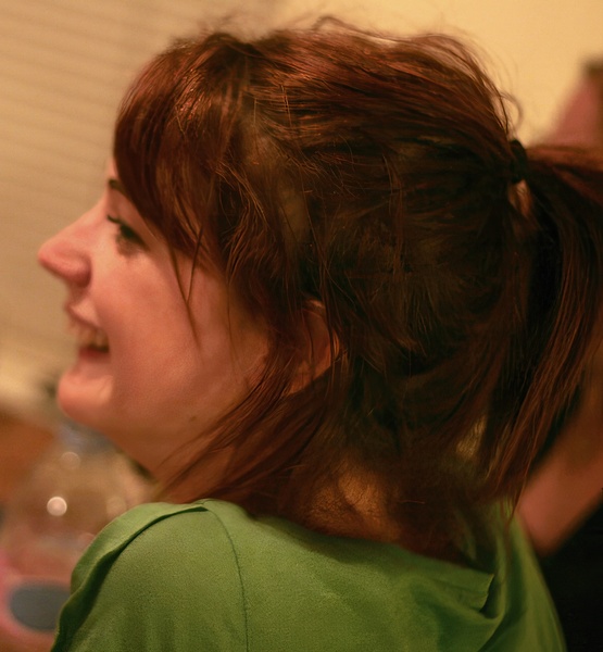 a woman with a green shirt is holding a cellphone