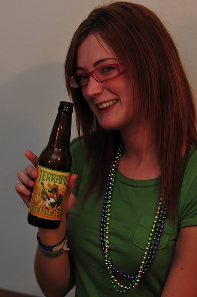 a woman in a green shirt holding a beer