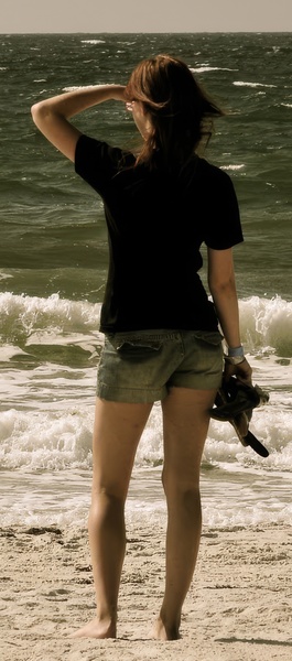 a woman standing on the beach with a camera