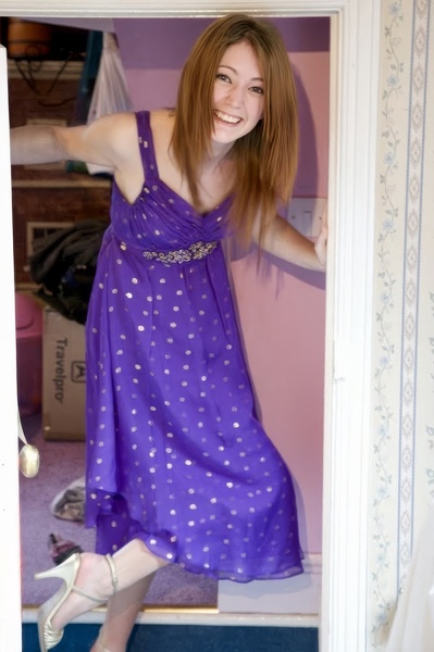 a woman in a purple dress is standing in a doorway