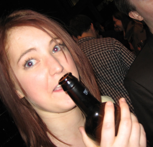 a woman holding a beer bottle