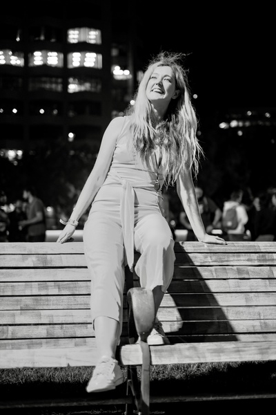 a woman sitting on a bench in the dark