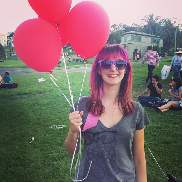 a woman holding two red balloons in her hands