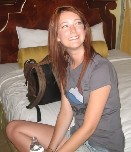 a woman sitting on a bed with a bag