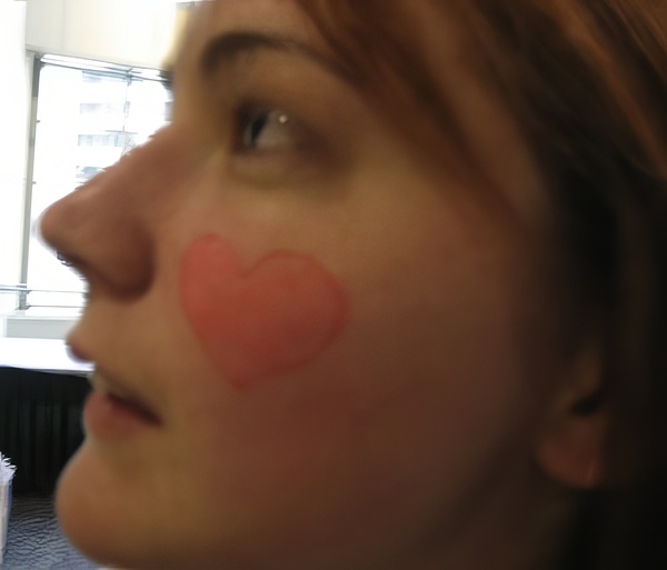 a woman with a pink nose painted on her face