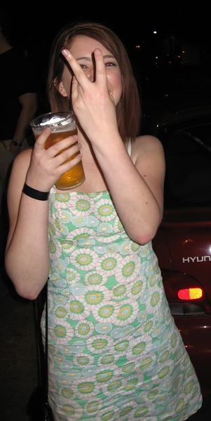 a woman drinking a beer from a glass