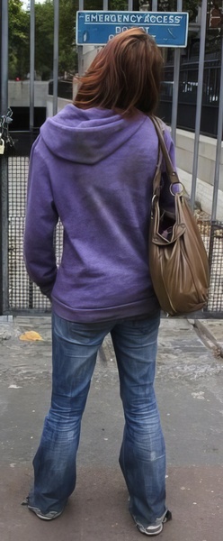 a woman in a purple jacket and jeans is walking down the street