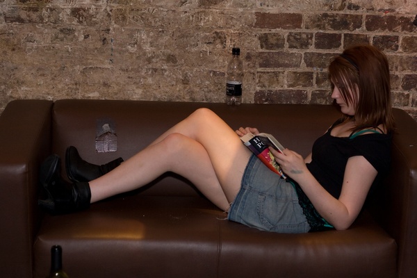 a woman sitting on a couch with a remote control