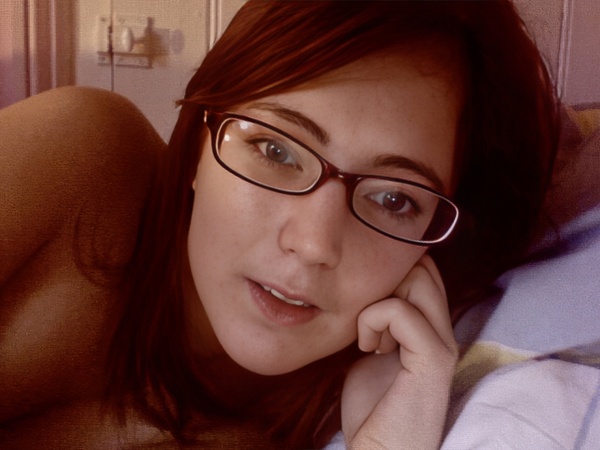 a woman laying on a bed with a teddy bear