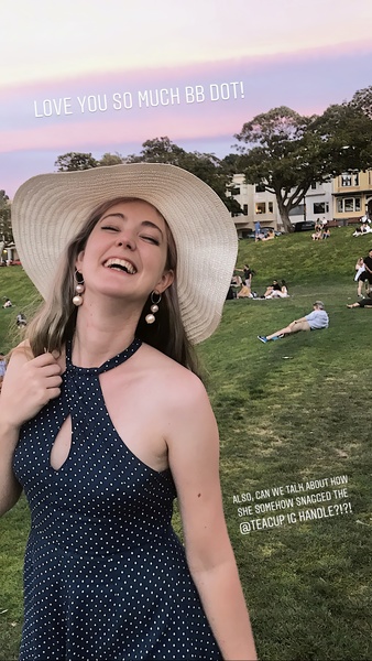 a woman in a hat smiles while standing in a field saoncay tthe