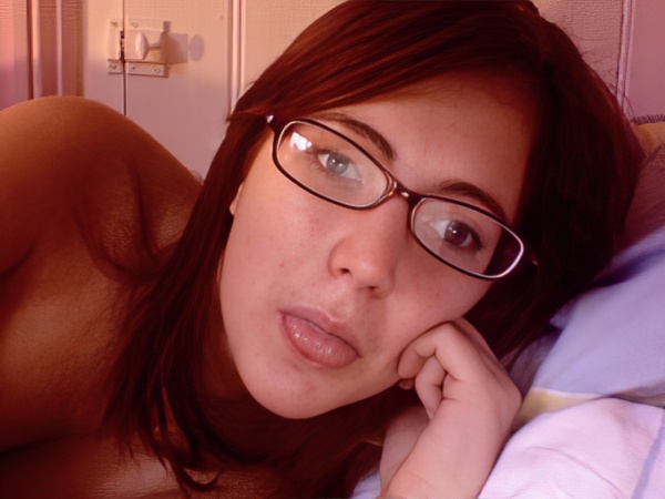 a woman laying on a bed with a pair of glasses on her face