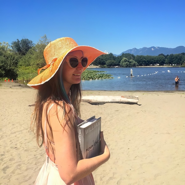 a girl in a hat and sunglasses is reading a book