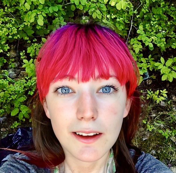 a woman with pink hair and blue eyes