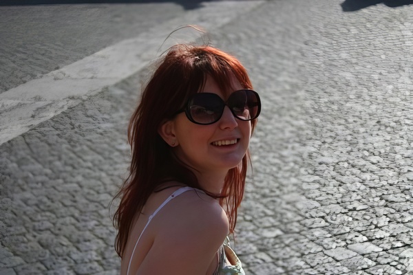 a woman with red hair and sunglasses on