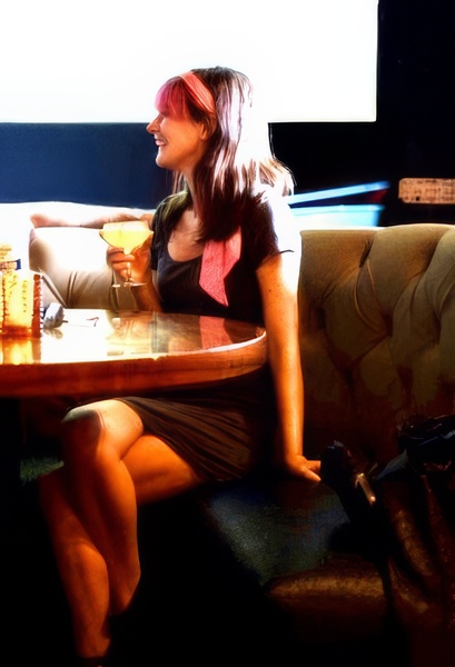 a woman sitting on a couch with a drink