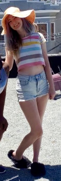 two girls in shorts and hats are standing on a roof