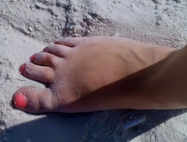 a person's foot with a red nail