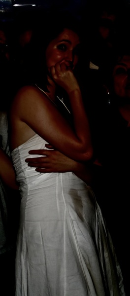 a woman in a white dress is hugging a man oe
pe

.* fl