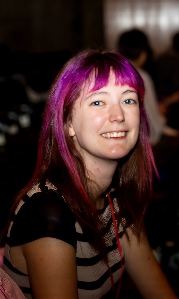 a woman with pink hair and a black and white shirt