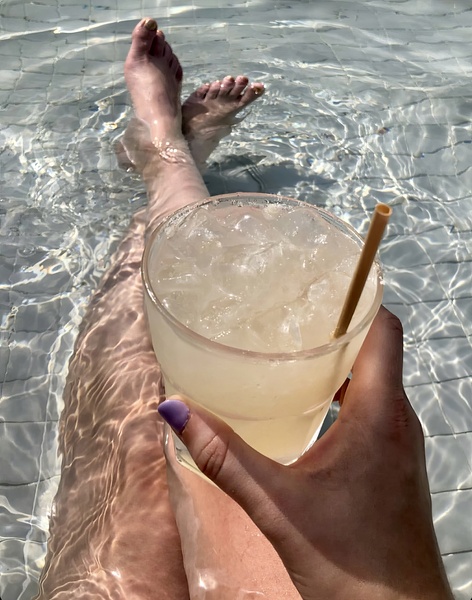 a person holding a drink in a pool