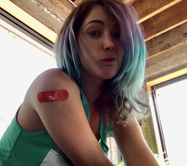 a woman with a green shirt and a red heart on her arm