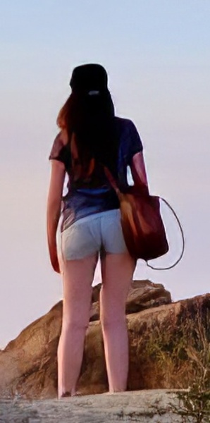 a woman standing on top of a rock