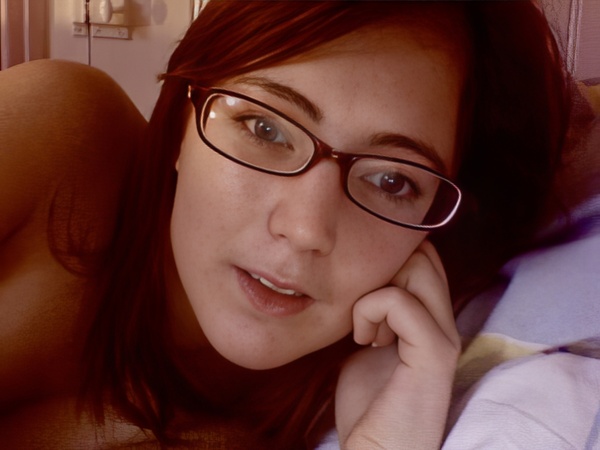 a woman laying on a bed with a pair of glasses on her face