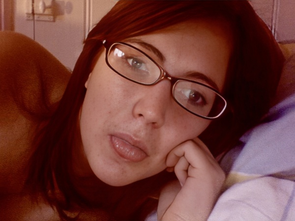 a woman laying on a bed with a teddy bear