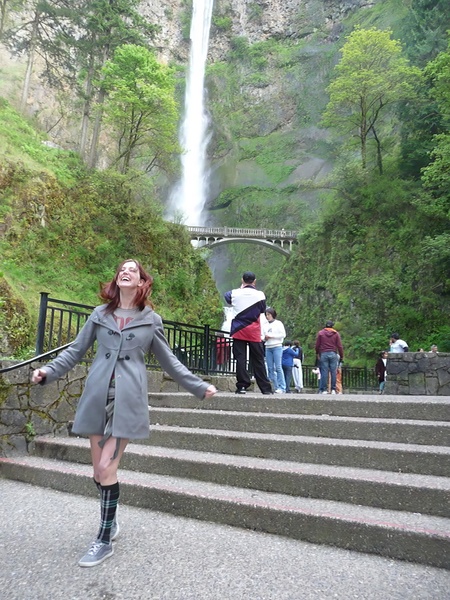 a woman in a gray coat is walking up some stairs