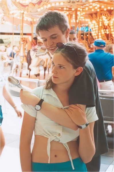 a man and a girl standing in front of a carousel