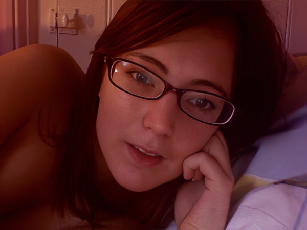 a woman laying on a bed with a pair of glasses on her face