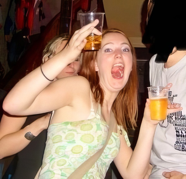 a woman holding a glass of orange juice