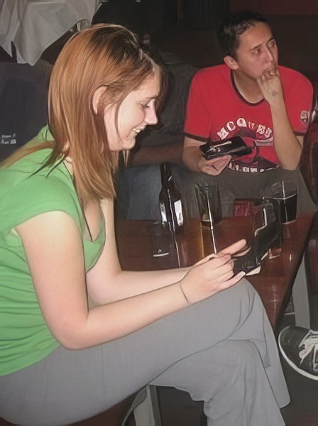 a woman sitting at a table with a cellphone