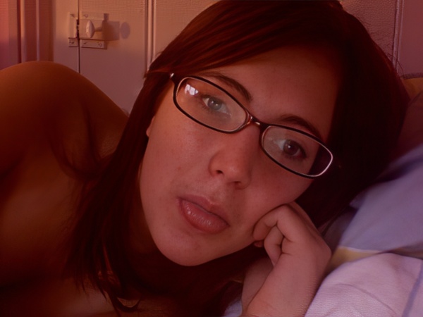 a woman laying on a bed with a pair of glasses on her face